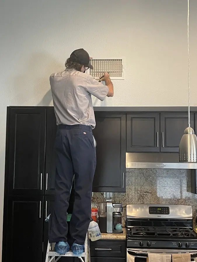 Technician inspecting an air vent during HVAC service in Landover